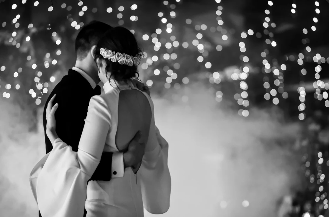 Un abrazo de boda bajo las luces